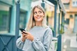 © Krakenimages.com - Young blonde girl smiling happy using smartphone at the city