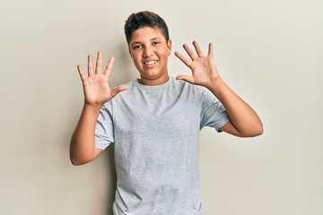 Sticker - Teenager hispanic boy wearing casual grey t shirt showing and pointing up with fingers number ten while smiling confident and happy.