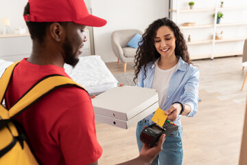 Wall Mural - Black delivery man holding POS machine for payment