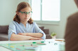 © spass - Portrait of pretty teen girl in glasses playing board game with parents