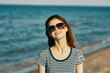 © SHOTPRIME STUDIO - cheerful woman in a t-shirt and glasses are resting on the seashore in the mountains
