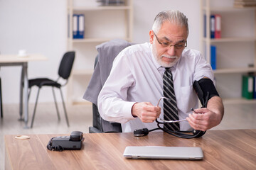 Aged male employee suffering at workplace