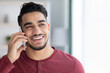 © Prostock-studio - Happy middle-eastern guy talking on mobile phone