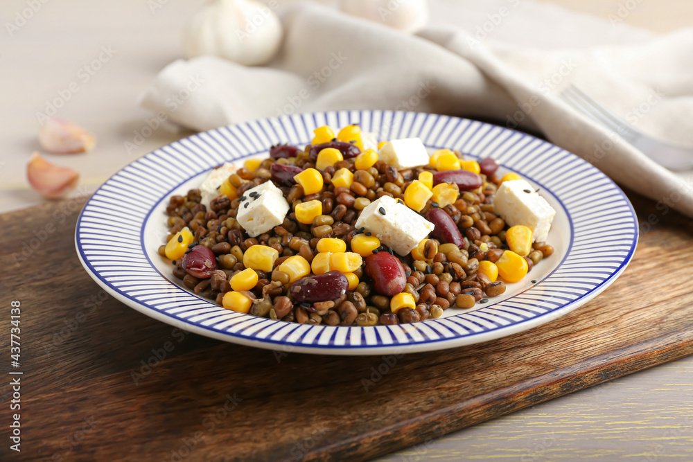 Plate with tasty cooked lentils, beans and cheese on table