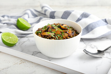 Bowl of tasty cooked lentils and mushrooms on table