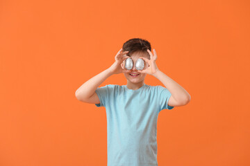 Canvas Print - Cute little boy with chocolate Easter eggs on color background