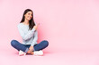 © luismolinero - Young caucasian woman isolated on pink background pointing finger to the side