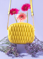 Canvas Print - Yellow fashion lady handbag with flowers on purple background with geometric podium