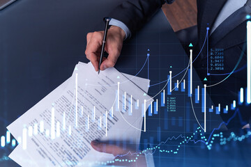 Wall Mural - A client in formal wear is signing the contract to invest money in stock market. Internet trading and wealth management concept. Forex and financial hologram chart over the desk.