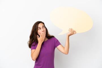 Young caucasian woman isolated on white background holding an empty speech bubble with surprised expression