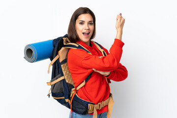 Wall Mural - Young caucasian mountaineer girl with a big backpack isolated on white background making strong gesture