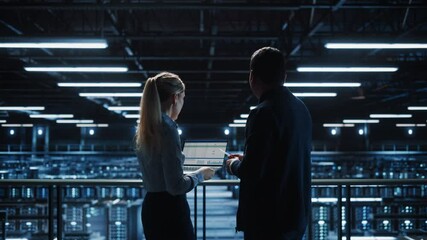 Leinwandbilder - Data Center Male It Specialist and Female e-Commerce Manager Talk, Use Laptop. Big Server Farm Cloud Computing Facility with Two Information Technology Professionals working. Medium Wide Shot