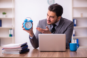 Wall Mural - Young businessman employee in time management concept