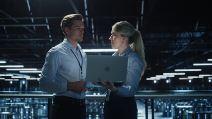Poster - Data Center Female e-Business Enrepreneur and Male IT Specialist talk, Use Laptop. Two Information Technology Professionals on Bridge Overlooking Big Cloud Computing Server Farm. Wide Medium Shot