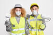 Shocked experienced maintenance workers paint apartment busy doing renovation repair and redecoration hold tools wear protective respirators hardhats and uniform isolated over white background