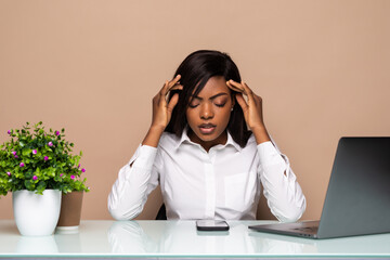 Stressed young african businesswoman sitting in office