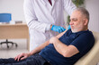 © Elnur - Old male patient visiting young male doctor in vaccination conce