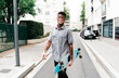 © PICHA - Man holding a skateboard