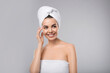 © New Africa - Happy young woman with towel on head against light grey background. Washing hair