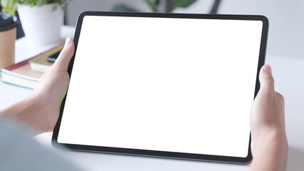 Wall Mural - close up of man hand holding digital tablet with blak screen on working table background for mock up
