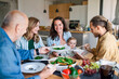 © Halfpoint - Happy multigeneration family indoors at home eating healthy lunch.