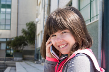 Wall Mural - student girl on the school stairs using mobile phone