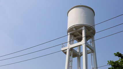 Concrete water tanks on the tower. Large outdoor white water tank for community water supply or large units on sky background with copy space.