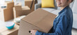 © StockPhotoPro - Happy woman carrying boxes in her new home