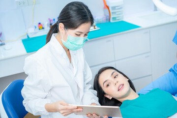 Wall Mural - Dentist doctor hold tablet, advice patient girl in dental care clinic