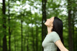 Leinwandbild Motiv Asian woman breathing fresh air in a forest