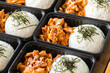 Korean food lunch boxes in plastic packages, Rice and spicy Korean pork stir-fry.