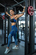 © nazarovsergey - Girl in sportswear standing near Smith machine at gym