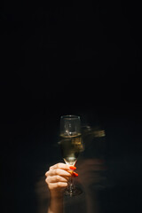 Sticker - Party fun. Sparkle champagne. Holiday celebration. Elegant female hand holding glass of fizzy wine drink long exposure defocused light isolated black.