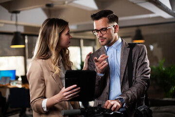 Wall Mural - Colleagues talking in the office. Businesswoman and businessman discussing work in office..