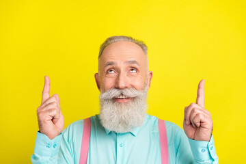 Sticker - Photo of beaming old man point look up wear blue shirt isolated on vivid yellow color background