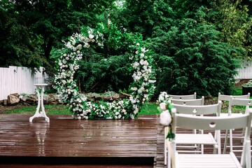 Wall Mural - Round arch for a wedding ceremony of green branches and flowers in the garden