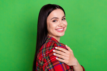 Profile side view portrait of attractive cheerful girl hugging herself isolated over bright green color background