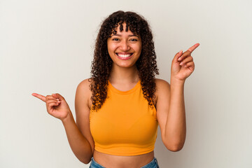 Poster - Young mixed race woman isolated on white background pointing to different copy spaces, choosing one of them, showing with finger.