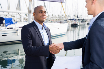 two men in suits buy and sell a yacht in the seaport