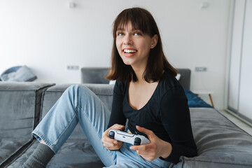 Happy young white woman holding joystick