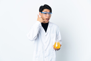 Poster - Young Chinese scientific man isolated on white background making phone gesture. Call me back sign