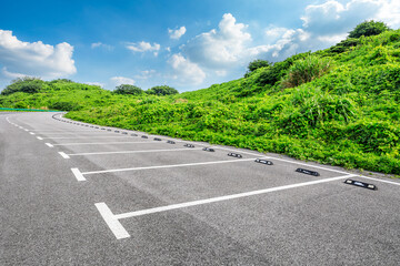 Asphalt parking lot and green mountain nature landscape.