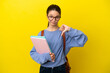 Student kid woman over isolated yellow background showing thumb down with negative expression