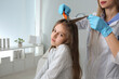 © New Africa - Doctor using nit comb on girl's hair in clinic. Anti lice treatment