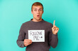 Young caucasian man holding a Follow me placard isolated on blue background having some great idea, concept of creativity.