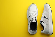 Pair Of Stylish Sports Shoes On Yellow Background, Flat Lay. Space For Text