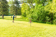 Disc Golf Is A Flying Disc Sport In Which Players Throw A Disc At A Target; It Is Played Using Rules Similar To Golf, This Player Is “putting” On A Course In Toronto.