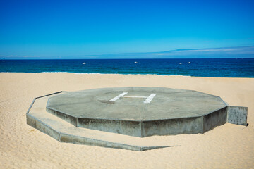 Heliport on the sand beach over blue sea view