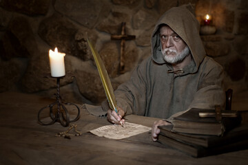 Old monk writes an old letter in the Middle Ages