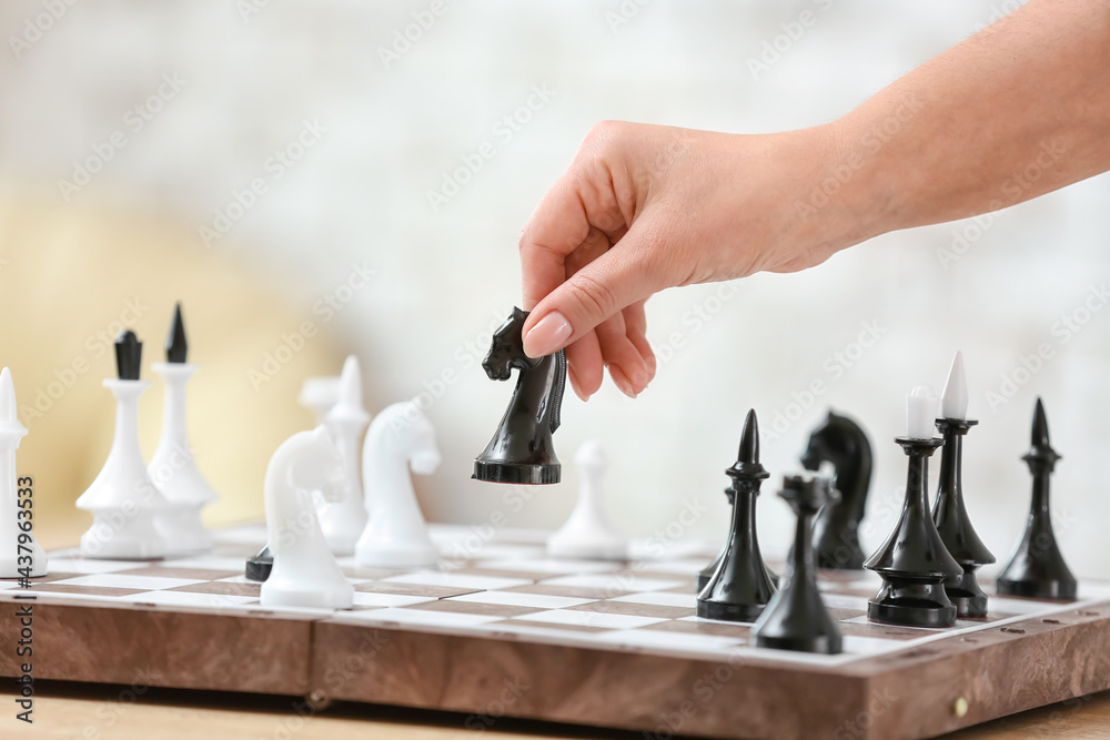 Young woman playing chess at home